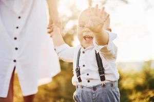 Young mother with her little son is outdoors in the forest. Beautiful sunshine photo