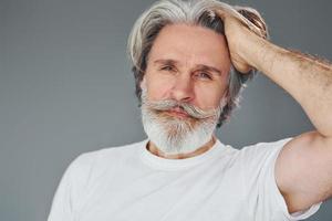 hermoso retrato un anciano moderno y elegante con pelo gris y barba está en el interior foto