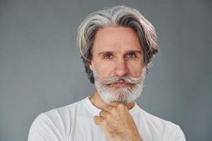 hermoso retrato un anciano moderno y elegante con pelo gris y barba está en el interior foto