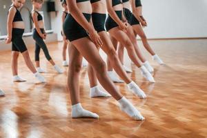 Group of female kids practicing athletic exercises together indoors photo