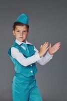 Cute little girl in blue stewardess uniform is posing for the camera photo