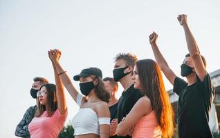 Fists rased high up. Group of protesting young people that standing together. Activist for human rights or against government photo