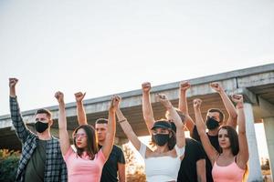 Fists rased high up. Group of protesting young people that standing together. Activist for human rights or against government photo