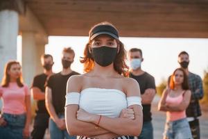 Beautiful girl in mask. Group of protesting young people that standing together. Activist for human rights or against government photo