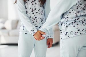 Holding each other's hand. Two cute little girls indoors at home together. Children having fun photo