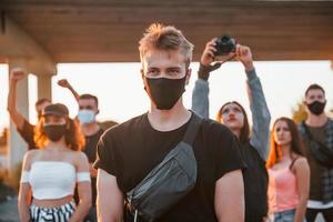 Guy at the front of crowd. Group of protesting young people that standing together. Activist for human rights or against government photo