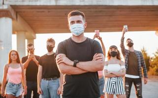 chico al frente de la multitud. grupo de jóvenes que protestan que se unen. activista por los derechos humanos o contra el gobierno foto