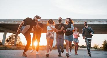 Embracing each other. Group of young cheerful friends having fun together. Party outdoors photo