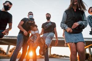 grupo de jóvenes amigos alegres divirtiéndose juntos. fiesta al aire libre foto