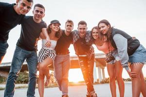 Posing for a camera. Group of young cheerful friends having fun together. Party outdoors photo