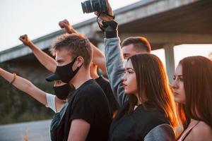 fotógrafo con cámara. grupo de jóvenes que protestan que se unen. activista por los derechos humanos o contra el gobierno foto