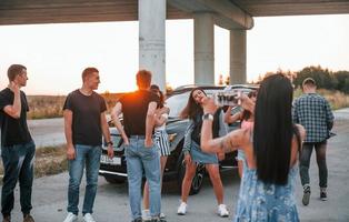 Talking and laughing. Group of young cheerful friends having fun together. Party outdoors photo