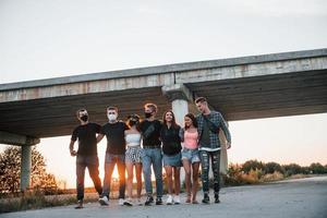 abrazándose unos a otros. grupo de jóvenes amigos alegres divirtiéndose juntos. fiesta al aire libre foto