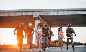 Running forward. Group of young cheerful friends having fun together. Party outdoors photo