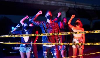 Yellow colored police tape. Group of protesting young people that standing together. Activist for human rights or against government photo