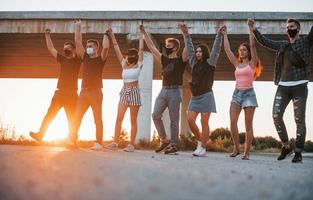 Embracing each other. Group of young cheerful friends having fun together. Party outdoors photo