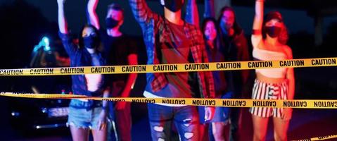 Yellow colored police tape. Group of protesting young people that standing together. Activist for human rights or against government photo