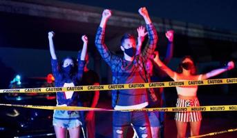 cinta policial de color amarillo. grupo de jóvenes que protestan que se unen. activista por los derechos humanos o contra el gobierno foto