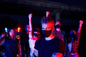 en máscaras protectoras. grupo de jóvenes que protestan que se unen. activista por los derechos humanos o contra el gobierno foto