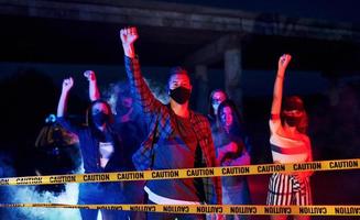 Yellow colored police tape. Group of protesting young people that standing together. Activist for human rights or against government photo