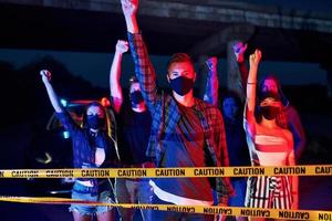 iluminación policial roja y azul. grupo de jóvenes que protestan que se unen. activista por los derechos humanos o contra el gobierno foto