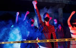 Yellow colored police tape. Group of protesting young people that standing together. Activist for human rights or against government photo