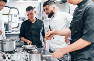 grupo de personas cocinando juntos en la cocina. día ajetreado en el trabajo foto