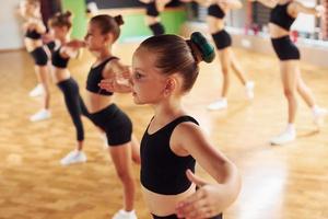 Active lifestyle. Group of female kids practicing athletic exercises together indoors photo