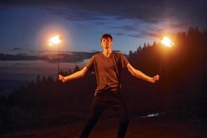 Fire show by man in night Carphatian mountains. Beautiful landscape photo