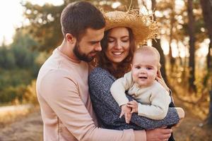 Unity of the people. Happy family of mother, family and little baby rests outdoors. Beautiful sunny autumn nature photo