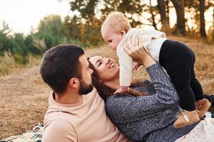 Haves picnic. Happy family of mother, family and little baby rests outdoors. Beautiful sunny autumn nature photo