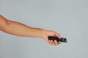 Close up view of man's hand that holding TV remote controller photo