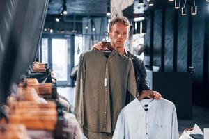 Quality products. Young guy in modern store with new clothes. Elegant expensive wear for men photo