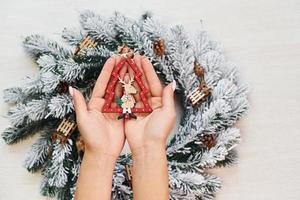 Woman's hands holds toys. Top view of christmas festive texture with new year decorations photo