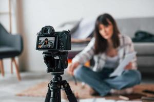 Camera is on the floor. Young female freelance worker is indoors in home at daytime photo