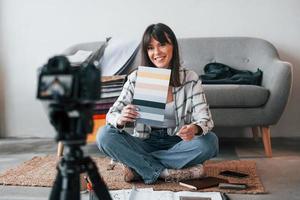 Camera is on the floor. Young female freelance worker is indoors in home at daytime photo