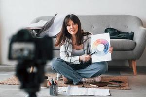 Camera is on the floor. Young female freelance worker is indoors in home at daytime photo