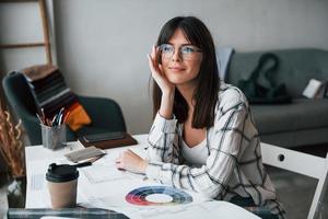 Young female freelance worker is indoors in home at daytime photo