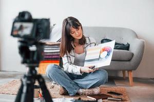 Camera is on the floor. Young female freelance worker is indoors in home at daytime photo