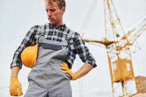 Takes a break. Construction worker in uniform and safety equipment have job on building photo