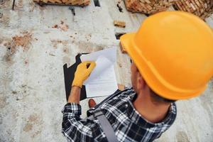 Top close up view of construction worker in uniform and safety equipment that have job on building photo