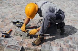 Male worker in yellow colored uniform have job with pavement photo