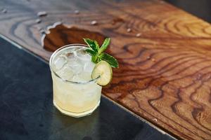 Green mint and yellow lime. Close up view of fresh summer cocktail on the wooden table photo