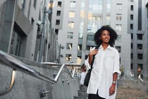 African american woman in good clothes is outdoors in the city at daytime photo