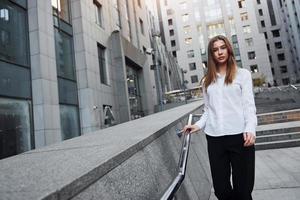 Beautiful young european woman is outdoors in the city at daytime photo