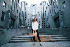 Beautiful young european woman is outdoors in the city at daytime photo