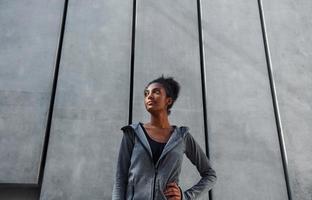 Young african american woman in sportive clothes have workout outdoors at daytime photo