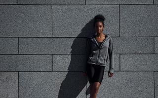 Young african american woman in sportive clothes have workout outdoors at daytime photo