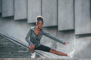 Conception of sport. Young african american woman in sportive clothes have workout outdoors at daytime photo