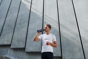 Young man in sportive clothes have workout outdoors at daytime photo